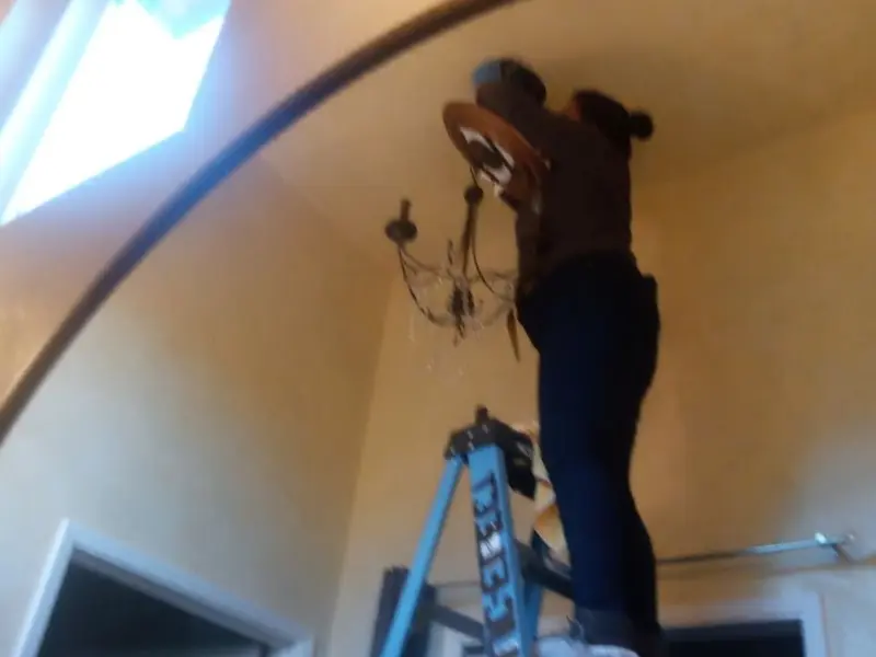 Electrician installing a chandelier in a Thonotosassa residence